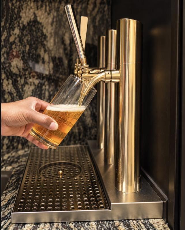 Close-up of the Bourbon Lounge's gold draft tap pouring a beer