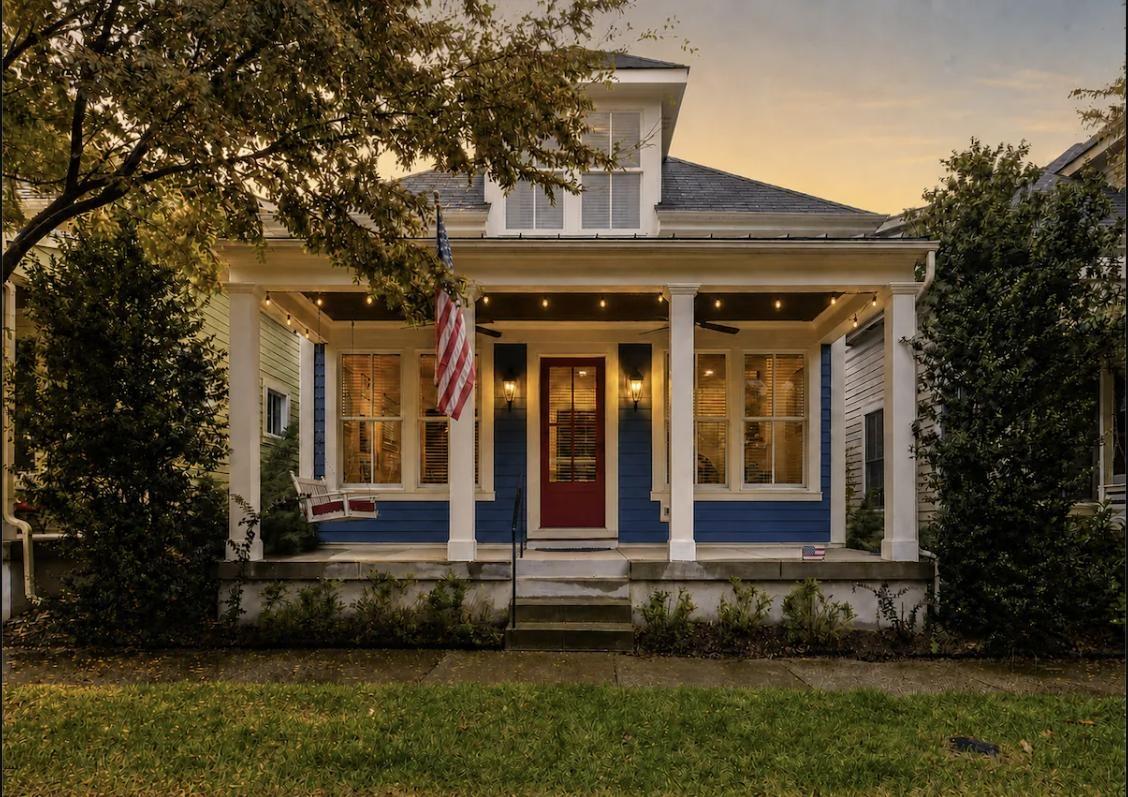 Delphinium Haus front exterior at dusk with string lights and an American flag